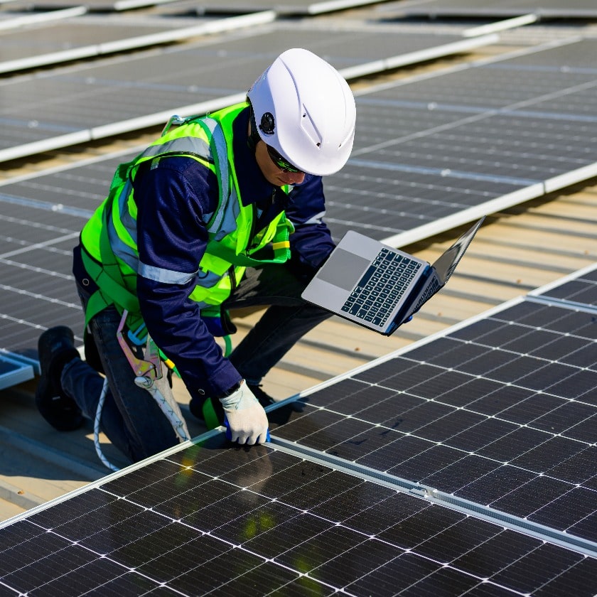 Engineer technician using laptop checking and operating system on rooftop of solar cell farm power plant, Renewable energy source for electricity and power, Solar cell maintenance concept